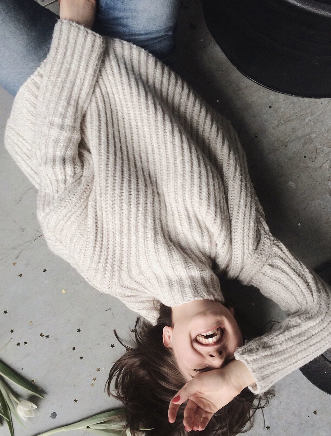 woman-wearing-gray-sweater-lying-on-gray-surface-1030926